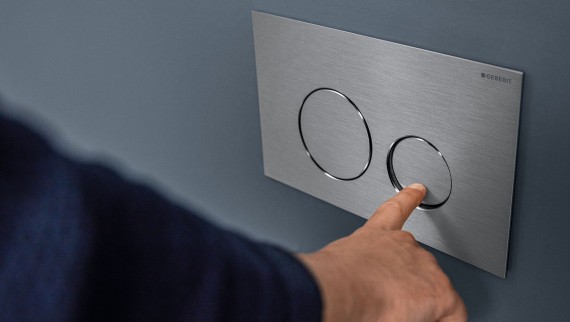 Hand löst kleine Spülung an der Sigma40 Betätigungsplatte mit runden Tasten aus (© Geberit) Hand löst kleine Spülung an der Sigma40 Betätigungsplatte mit runden Tasten aus (© Geberit)