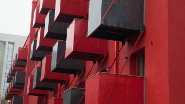 Une façade rouge marquante avec des balcons cubiques en saillie est le nouveau point de mire de la Goldsteinstrasse à Francfort-sur-le-Main (DE) (© Geberit)