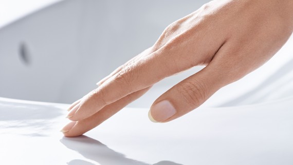 Una mano accarezza la ceramica del lavabo con rivestimento KeraTect Una mano accarezza la ceramica del lavabo con rivestimento KeraTect