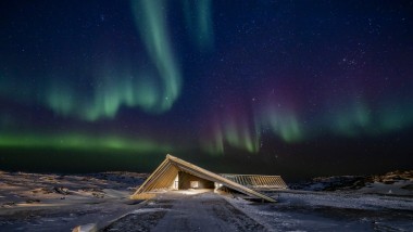 Le Centre du fjord glacé sous les spectaculaires aurores boréales de la nuit polaire groenlandaise (© Adam Mørk)